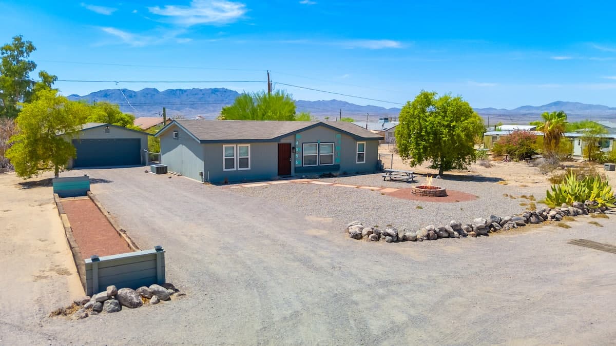Front of Casa de Topock with the gravel driveway and desert mountains behind it