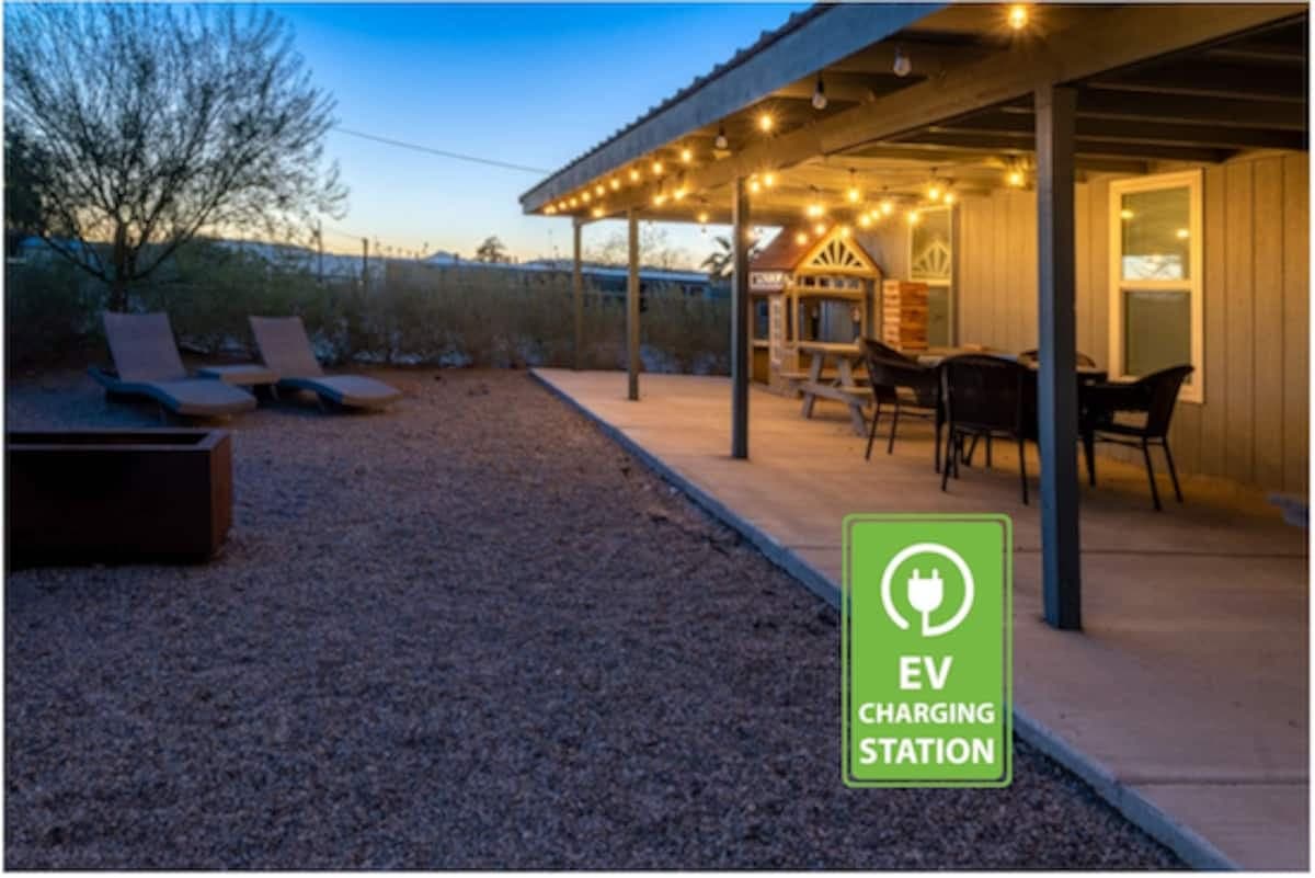 Covered outdoor patio with dining area and EV charging station