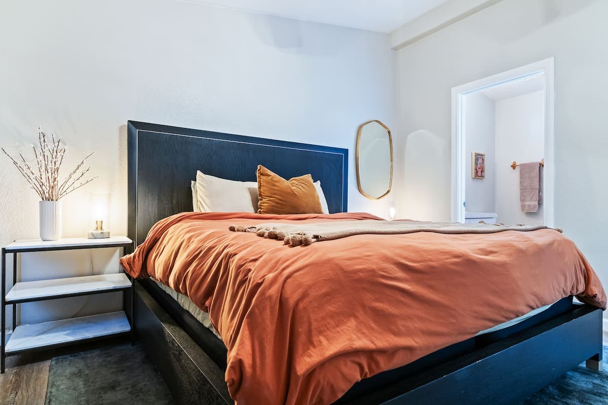 King bedroom with rust-colored bedding and bedside tables